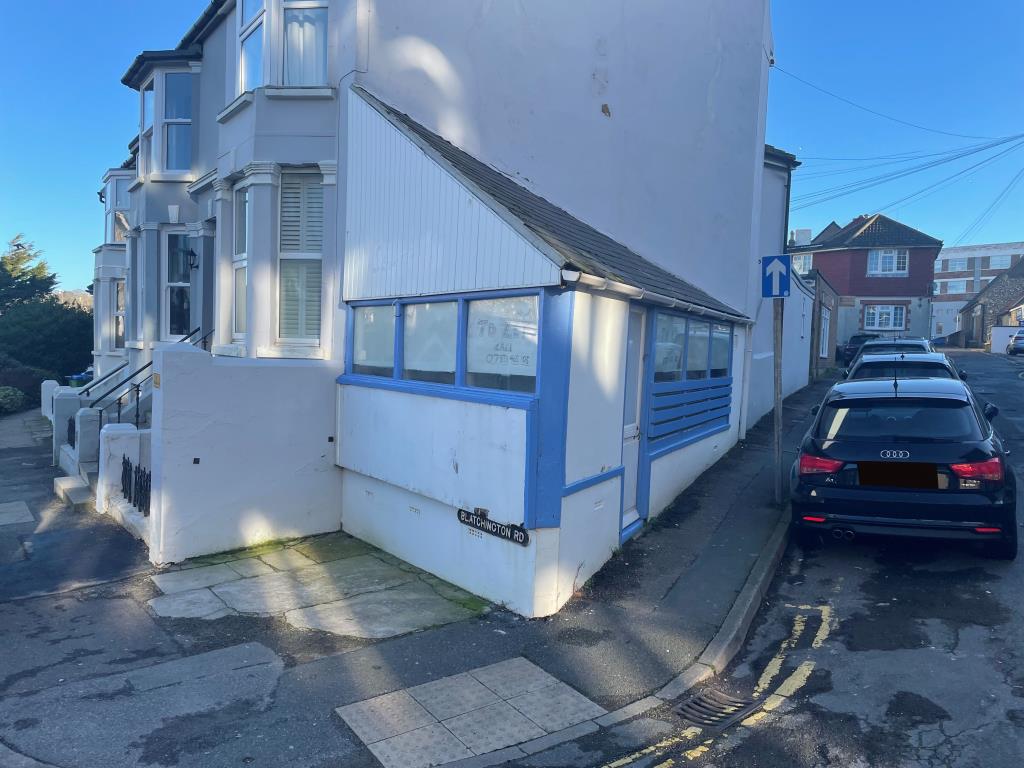 Lot: 113 - SMALL LOCK-UP SHOP IN CENTRAL LOCATION - Front view of property from road junction